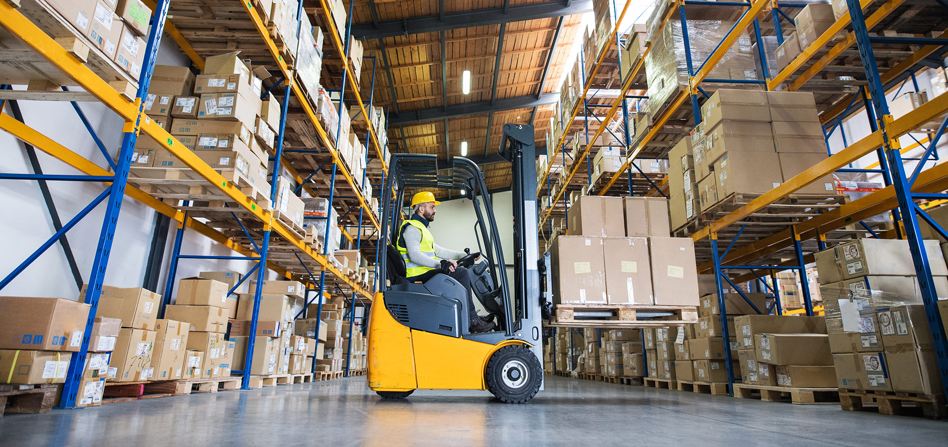 A fork lift driver moving boxes about a warehouse